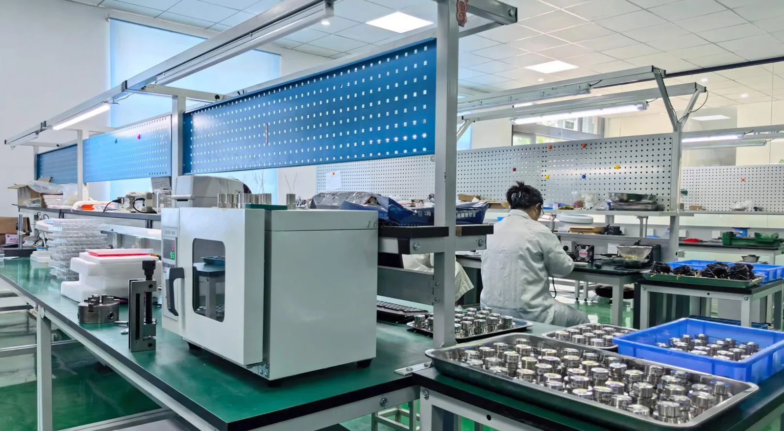 Assembly and test bench at SourceMech with instruments on inspection trays